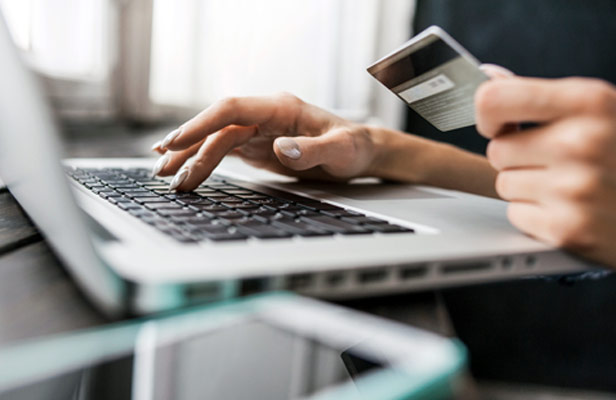 woman typing credit card info onto laptop computer